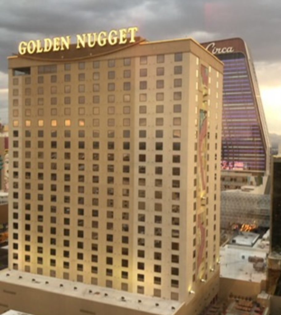 a photo of the Golden Nugget hotel at sunset with the lights of the hotel sign on.