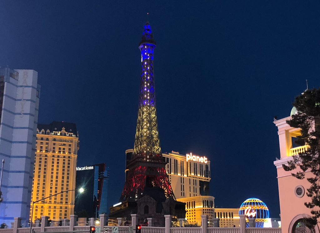 A photo of Las vegas at night with a small version of the Eifel tower in the centre of the photo